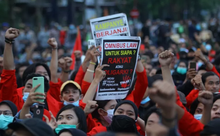  Demonstran yang tergabung dalam Gerakan Tolak Omnibus Law (GETOL) membentangkan poster saat berunjuk rasa di depan Gedung Negara Grahadi di Surabaya, Jawa Timur, Selasa 20 Oktober 2020. Para demonstran yang terdiri atas pekerja dan mahasiswa menentang pengesahan Undang-undang Cipta Kerja yang mereka nilai merugikan rakyat. (Foto: Antara/Moch Asim)