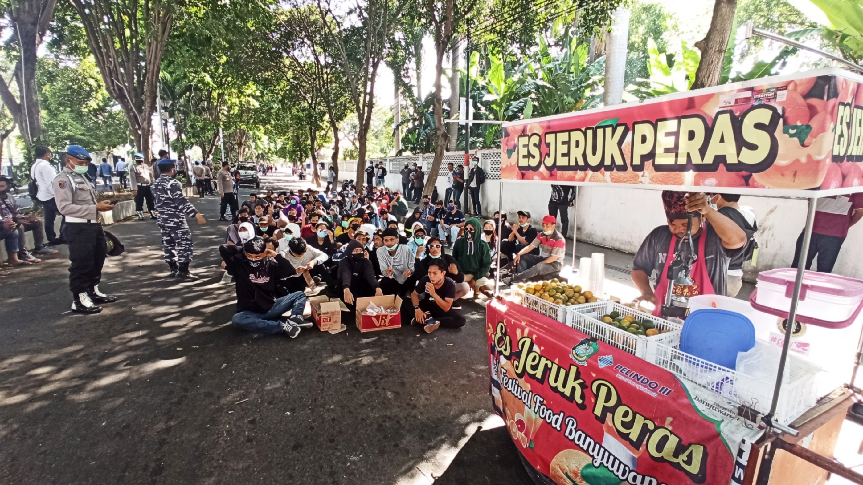 Sejumlah pelajar yang hendak melakukan unjuk rasa ditraktir minum es Jeruk oleh petugas keamanan (foto:Muh Hujaini/Ngopibareng.id)