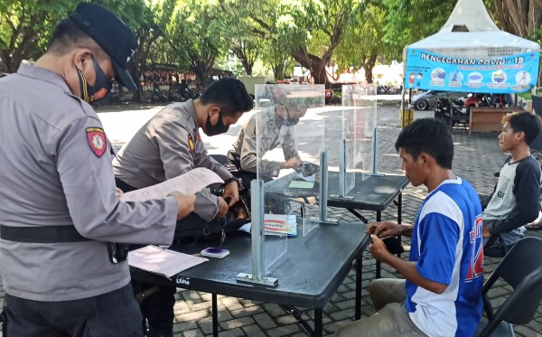 Foto dokumentasi petugas memberikan sanksi pada warga yang tidak mengenakan masker (Foto: Muh Hujaini/Ngopibareng.id)