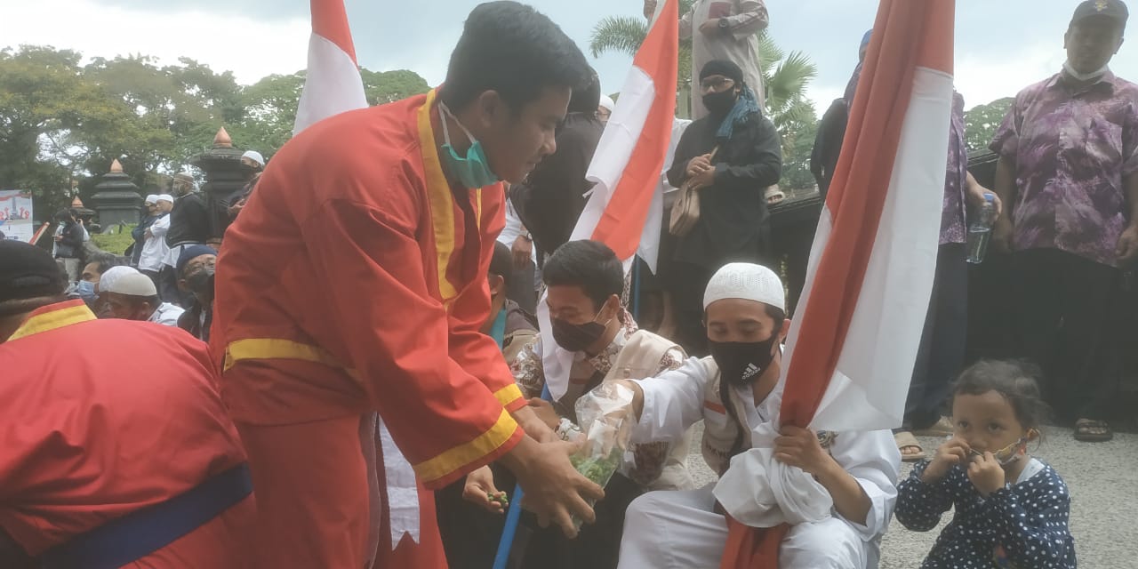 Gerakan makan makaroni bersama yang dilakukan oleh massa Aksi Aliansi Malang Kondusif untuk mengecam Presiden Prancis, Emmanuel Macron (Foto: Lalu Theo/ngopibareng.id)