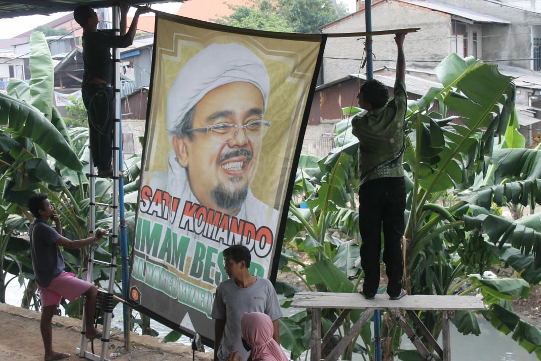 Pemasangan baliho  di wilayah Jakarta Barat, menjelang kepulangan Imam Besar FPI Habib Rizieq. ( foto: asmanu/ngopibareng.id).