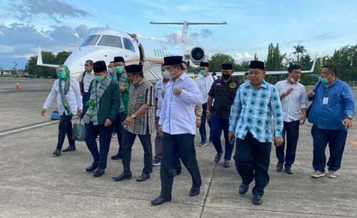 Plt. Ketua Umum PPP Suharso Monoarfa, paling depan kedua dari kiri berbaju hijau dengan slempang, turun dari pesawat pribadi di bandara. (Foto:Istimewa). 