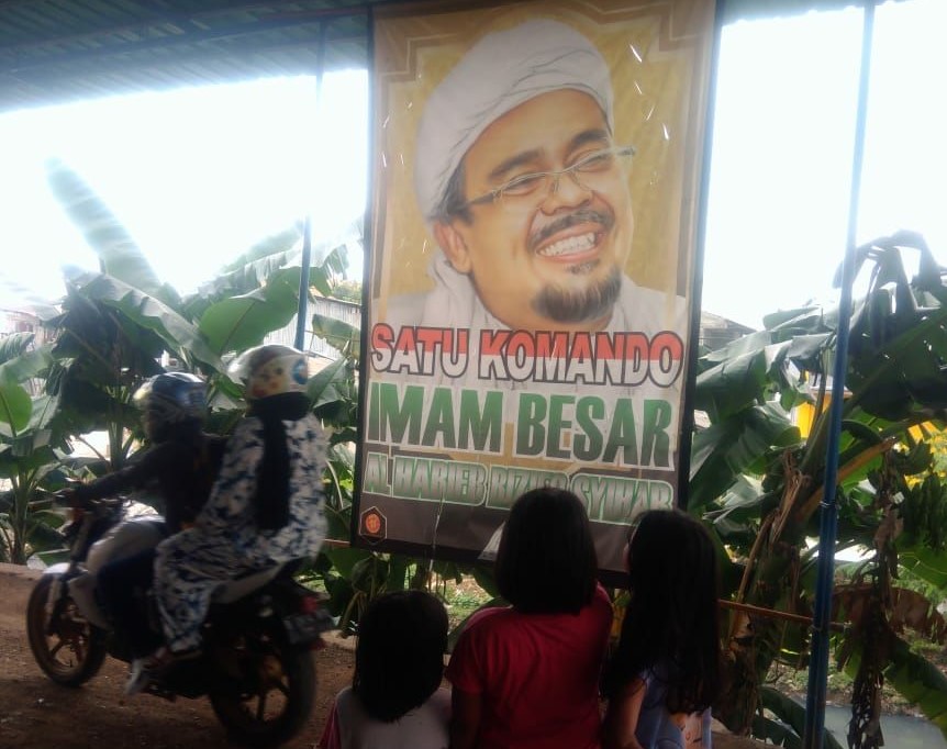 Sebuah Baliho Rizieq di Kampung Rawa Jakarta yang lolos dari pembersihan, jadi tontonan anak anak. ( foto: ngopibareng.id/Asmanu)