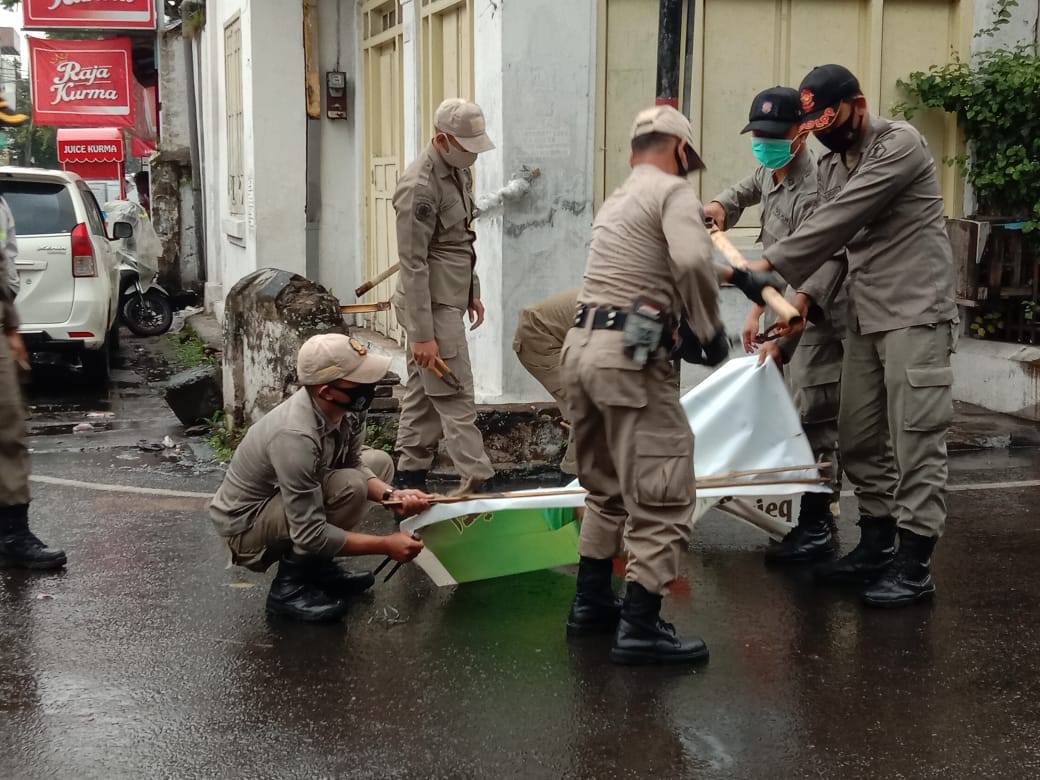 Pencopotan baliho atau reklame yang memampang foto Imam Besar FPI, Habib Rizieq Syihab di Jalan Syarif Al-Qodri, Kota Malang (Foto: istimewa)