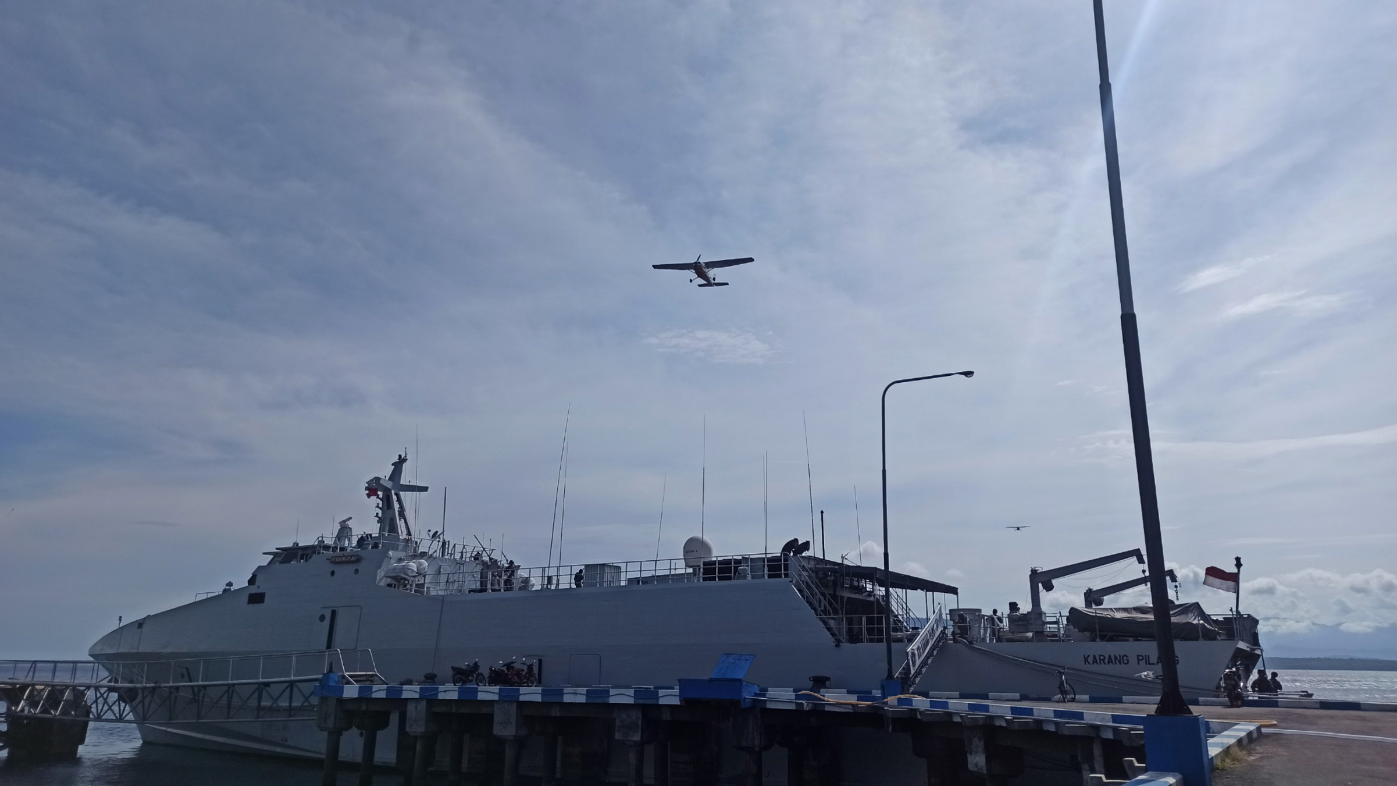 Sebuah pesawat melintas di atas KRI Karang Pilang dalam gladi tugas tempur yang digelar Lanal Banyuwangi (Foto: Muh Hujaini/Ngopibareng.id)
