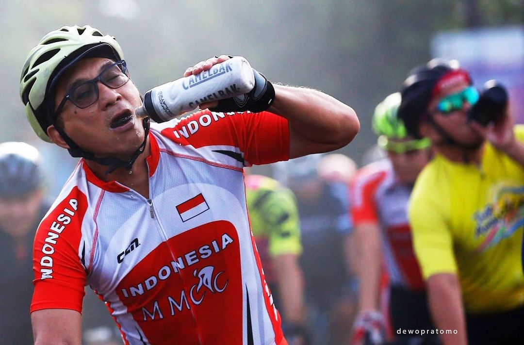 Minum saat bersepeda bukan perkara mudah. Baiknya berhenti di tempat aman saja. (Foto: Dewo Pratomo)