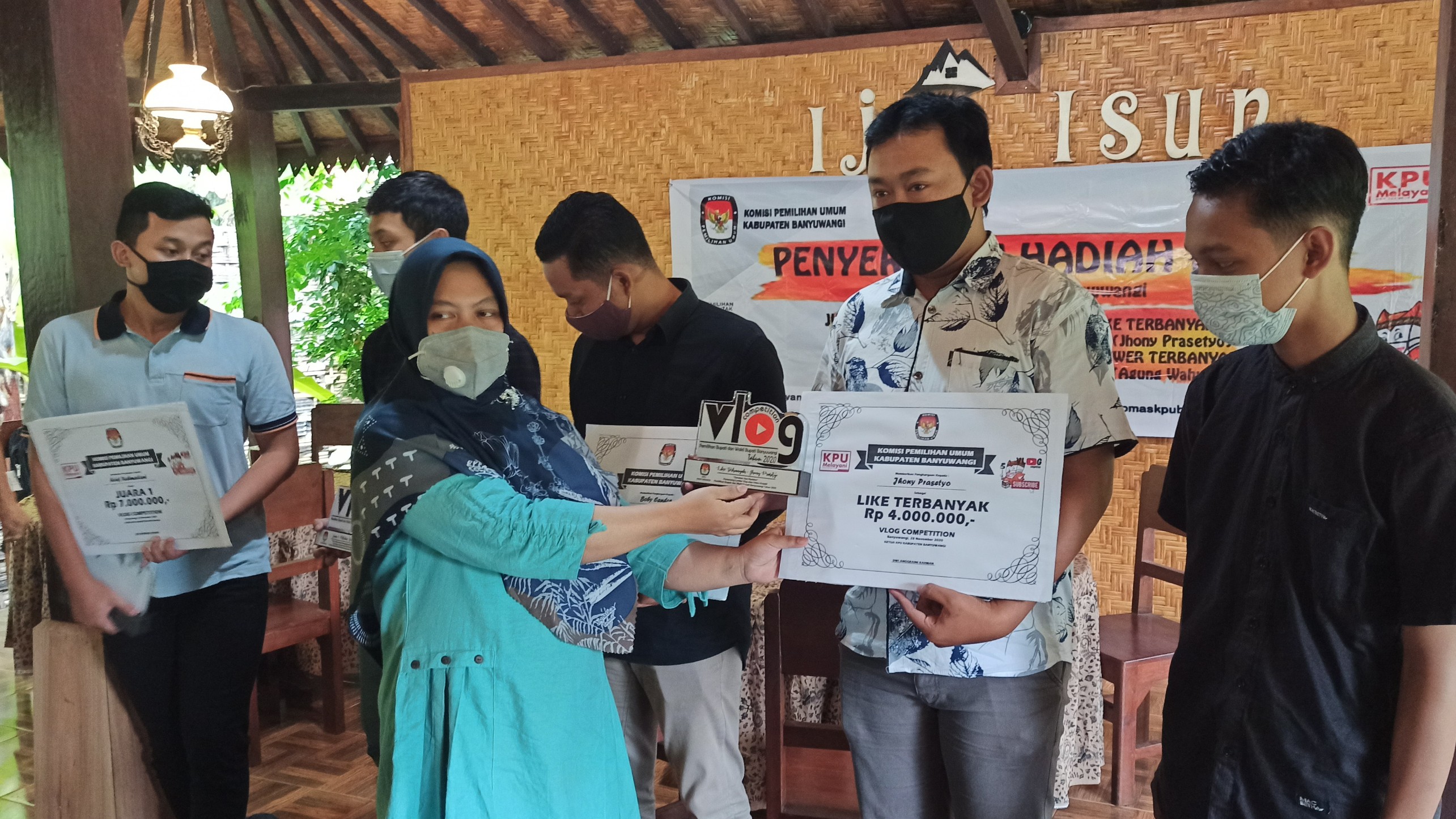 Ketua KPU Banyuwangi, Dwi Anggraini menyerahkan hadiah kepada pemenang lomba vlog. (Foto: Muh Hujaini/Ngopibareng.id)