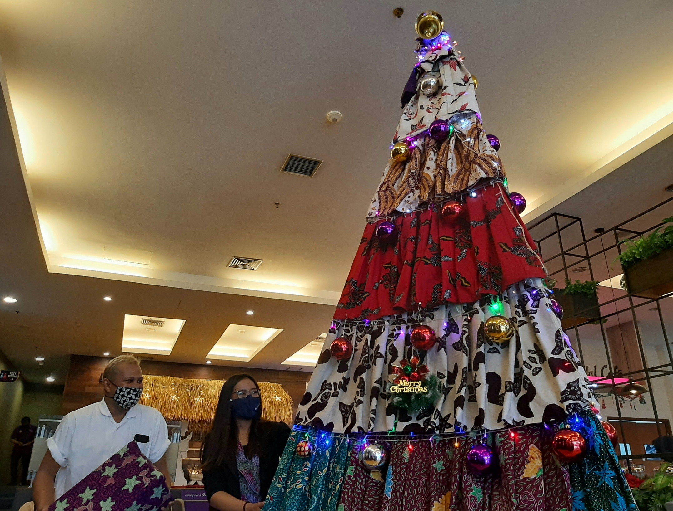 Emran Nawawi dan Melly Aruni saat menata poon Natal dari Batik Pamekasan. (Foto: Pita Sari/Ngopibareng.id)