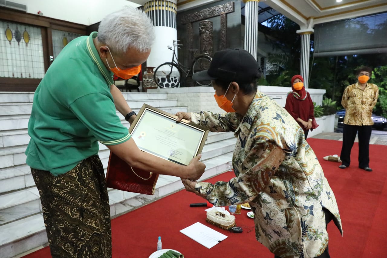 Gubernur Jawa Tengah, Ganjar Pranowo memberikan piagam Tokoh Teladan Kejujuran kepada pemulung bernama Bapak Mulyadi, 