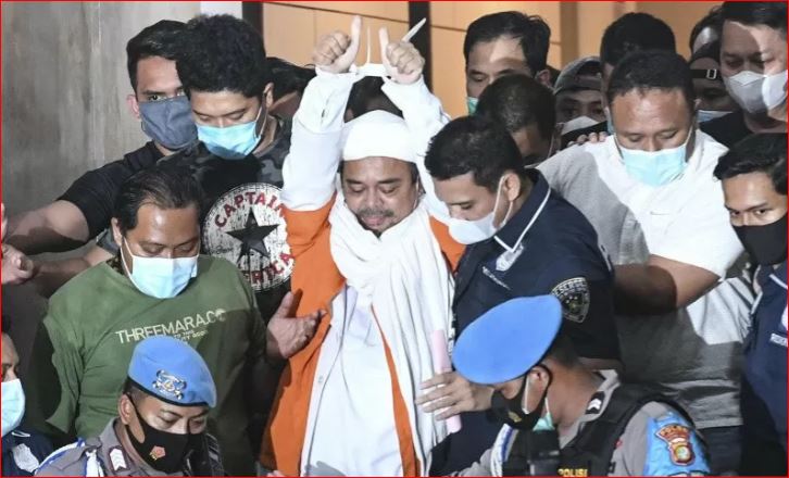 Dengan tangan yang terikat, Rizieq Syihab berjalan menuju mobil tahanan usai diperiksa di Polda Metro Jaya semalam. (Foto: Antara/ Hafidz Mubarak A)