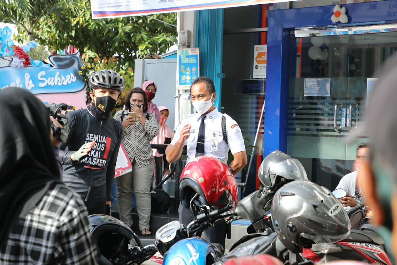 Gubernur Jawa, Tengah Ganjar Pranowo mengingatkan warga yang sedang antre Banpres Produktif Usaha Mikro (BPUM) di Bank BRI KCP Mataram untuk menerapkan protokol kesehatan.