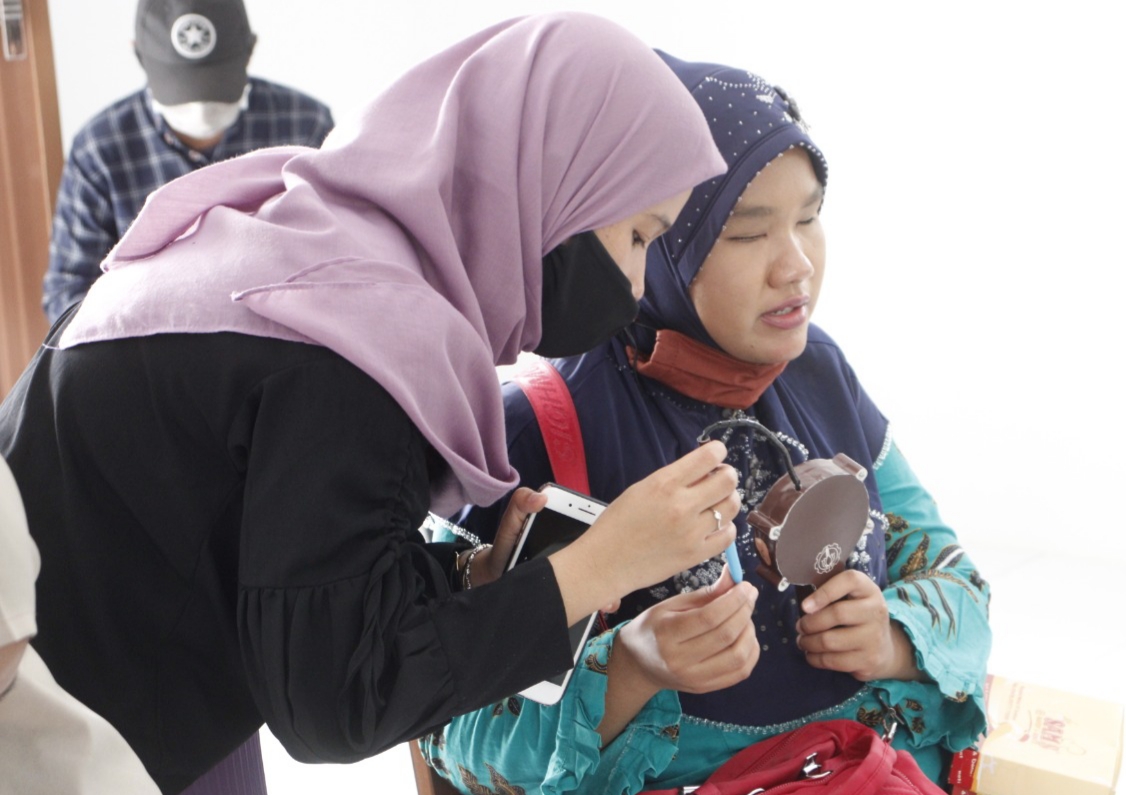 Tim ITS sedang mengajarkan cara kerja temometer pada seorang tuna netra. (Foto: istimewa)