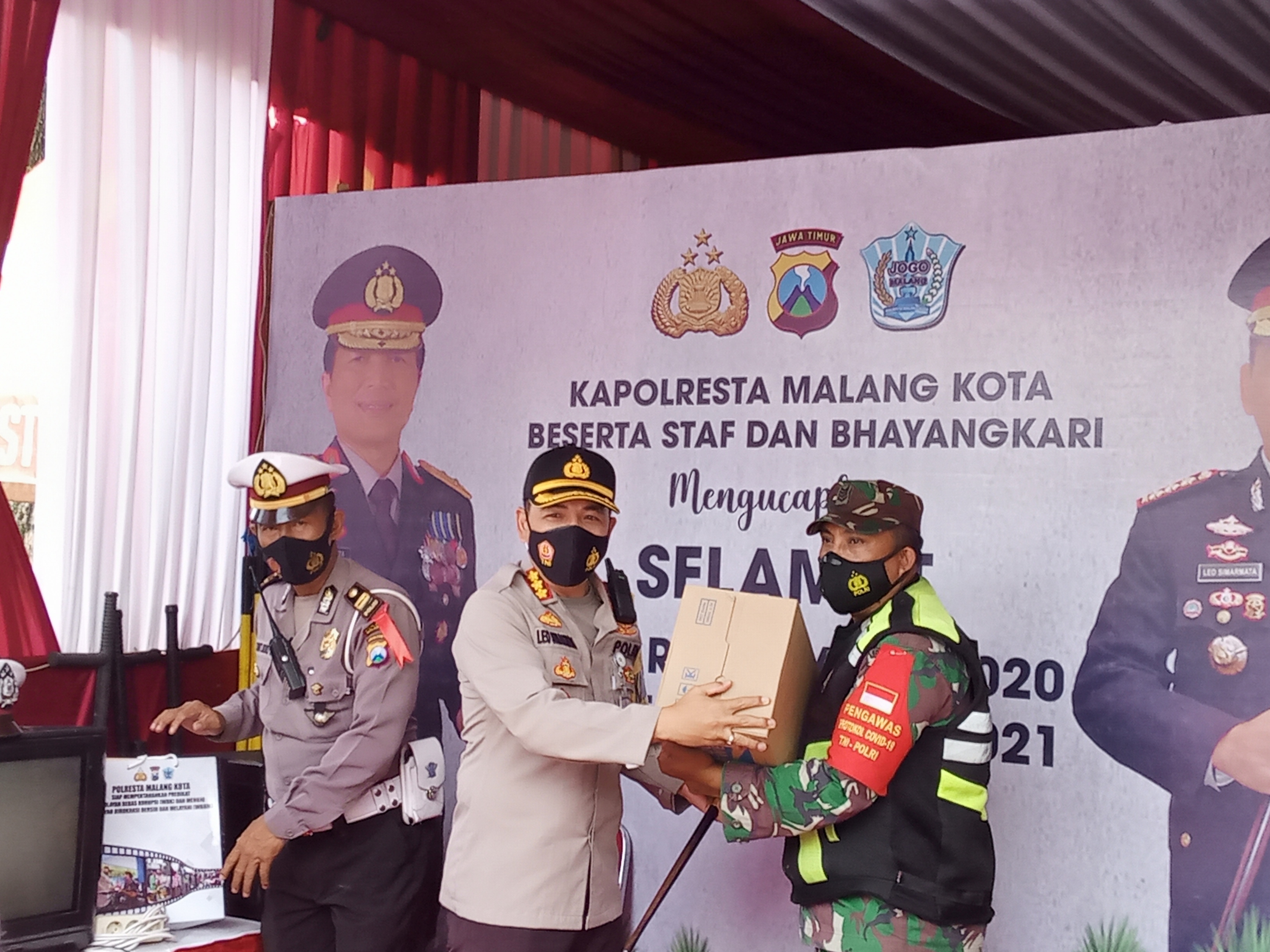 Kapolresta Malang Kota, Kombes Pol Leonardus Simarmata saat membagikan masker kepada petugas yang berjaga di Pos Pengamanan di Gereja Kayutangan. (Foto: Lalu Theo/Ngopibareng.id)