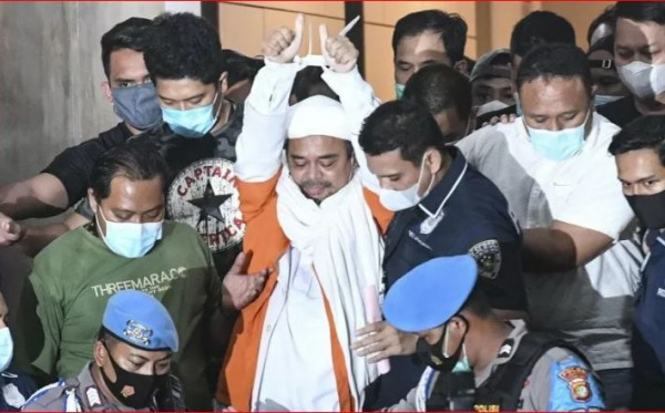 Dengan tangan yang terikat, Rizieq Syihab berjalan menuju mobil tahanan usai diperiksa di Polda Metro Jaya semalam. (Foto: Antara/ Hafidz Mubarak A)