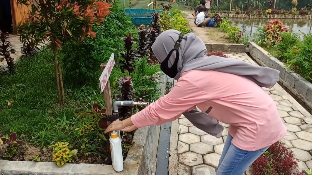 Salah seorang pengunjung Warung Taman Langit sedang mencuci tangan begitu tiba di lokasi. (Foto: Muh Hujaini/Ngopibareng.id)