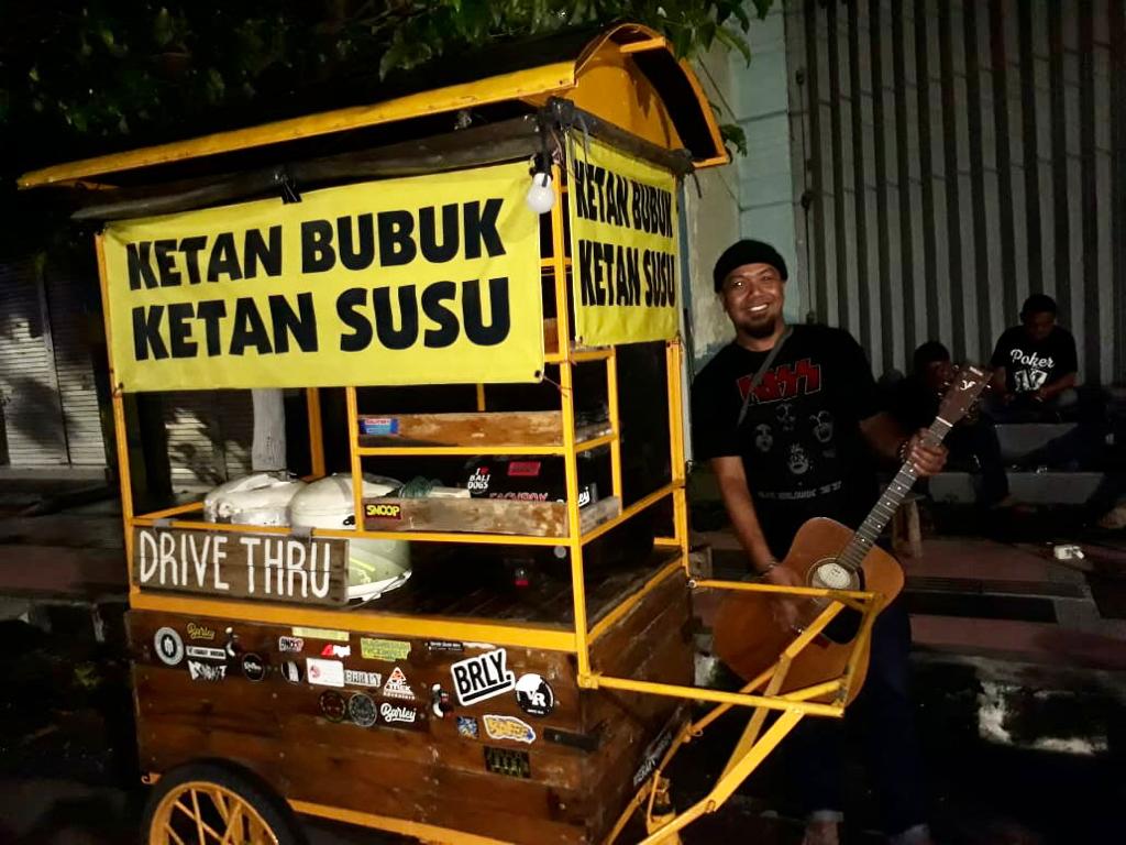 Arif Agus Setiawan bersama gerobak dagangannya yang harus tutup jam 20.00 WIB, Kamis, 31 desember 2020. (Foto: Choirul Anam)