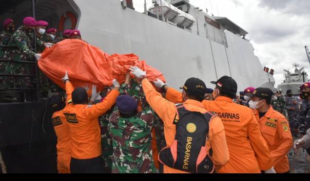 Tim SAR gabungan evakuasi serpihan pesawat Sriwijaya Air SJ-182 dan pakaian anak dari KRI Kurau ke Posko Terpadu JICT 2, Tanjung Priok, Jakarta. (Foto: Twitter Basarnas)