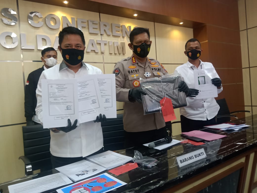 Kabid Humas Polda Jatim, Kombes Pol Gatot Repli (tengah) bersama Direktur Ditreskrimsus Polda Jatim, Kombes Pol Farman menunjukkan barang bukti surat rapid antigen palsu di Mapolda Jatim, Surabaya, Senin 11 Januari 2021. (Foto" Fariz Yarbo/Ngopibareng.id)