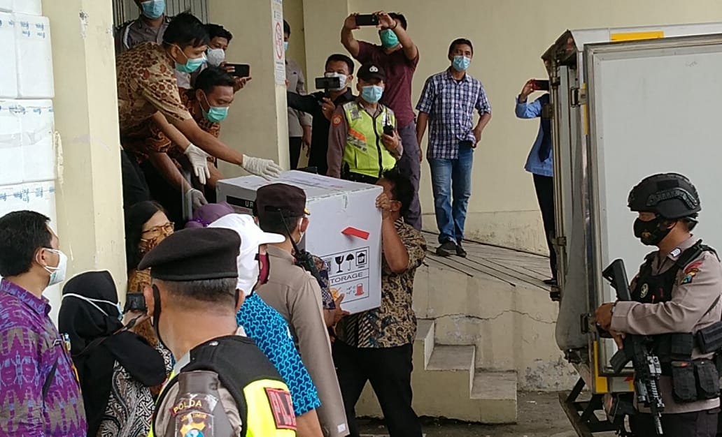 Petugas Dinkes Kota Surabaya melakukan pemindahan vaksin dari mobil box ke cold room di Gedung Farmasi Kesehatan, Surabaya, Rabu 13 Januari 2021. (Foto: Fariz Yarbo/Ngopibareng.id)