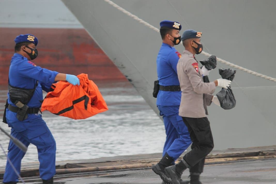 Petugas Membawa  kantong jenazah yang ditemukan tim SAR  untuk diserahkan pada Tim DVI Posko Gabung IJCT Tanjung Priok Jakarta. ( foto: Asmanu/ngopibareng.id)