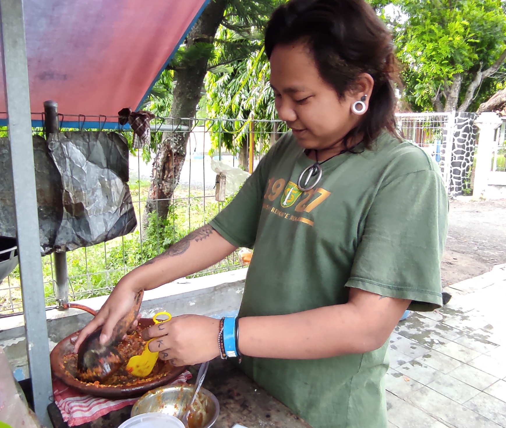 Anak punk piawai nguleg sambal penyetan. (Foto: Fendhy Plesmana/Ngopibareng.id)