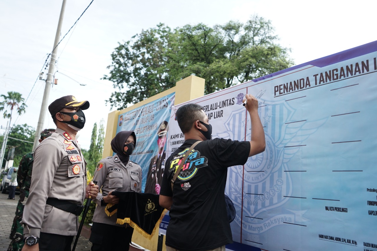 Seorang remaja menandatangani ikrar bersama tidak akan melakukan balap liar lagi. (Foto: Ikhsan Mahmudi/Ngopibareng.id)