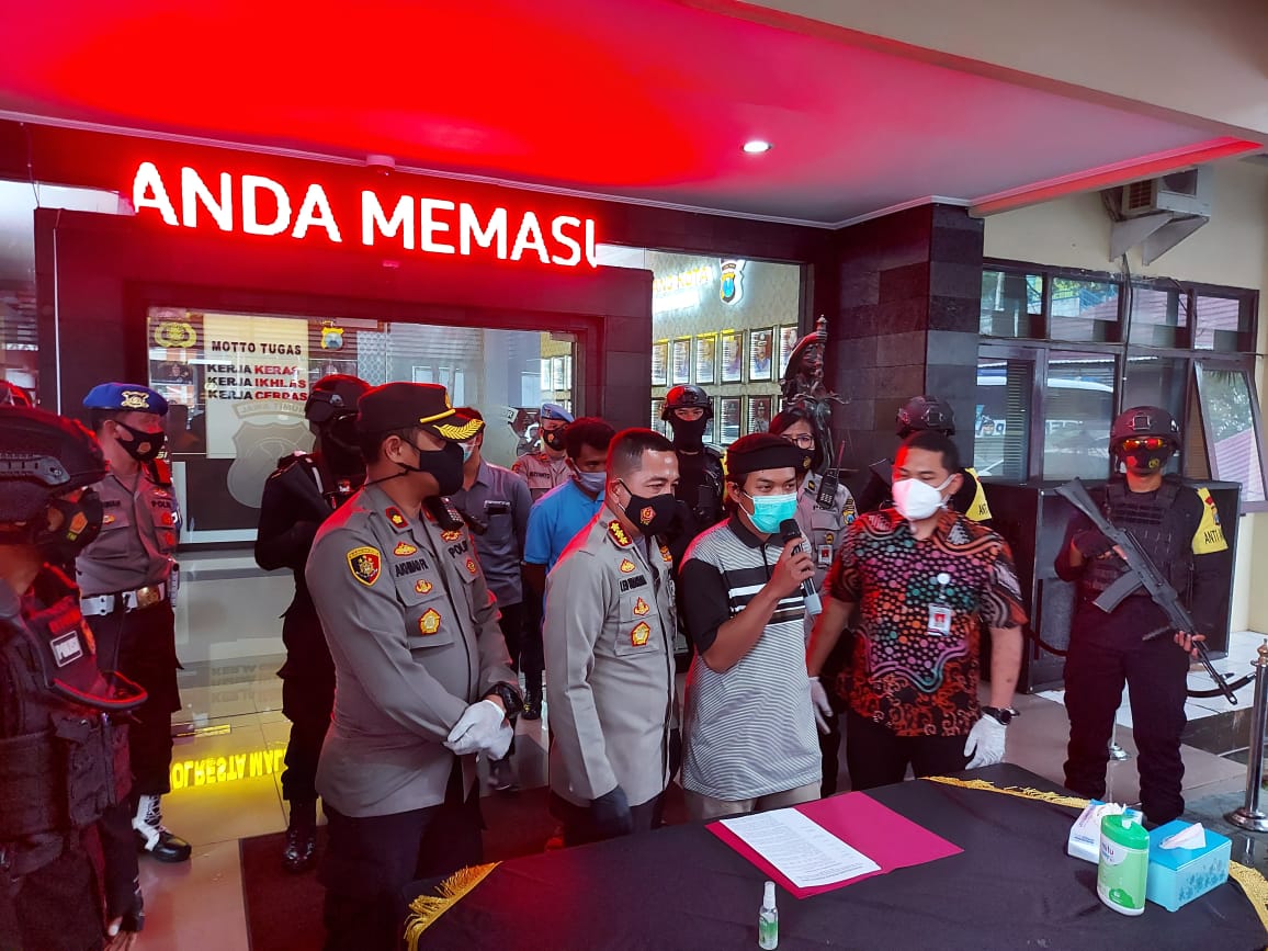 Tersangka penganiayaan petugas pemakaman, MNH saat berada di Halaman Mapolresta Malang Kota (Foto: Lalu Theo/Ngopibareng.id)