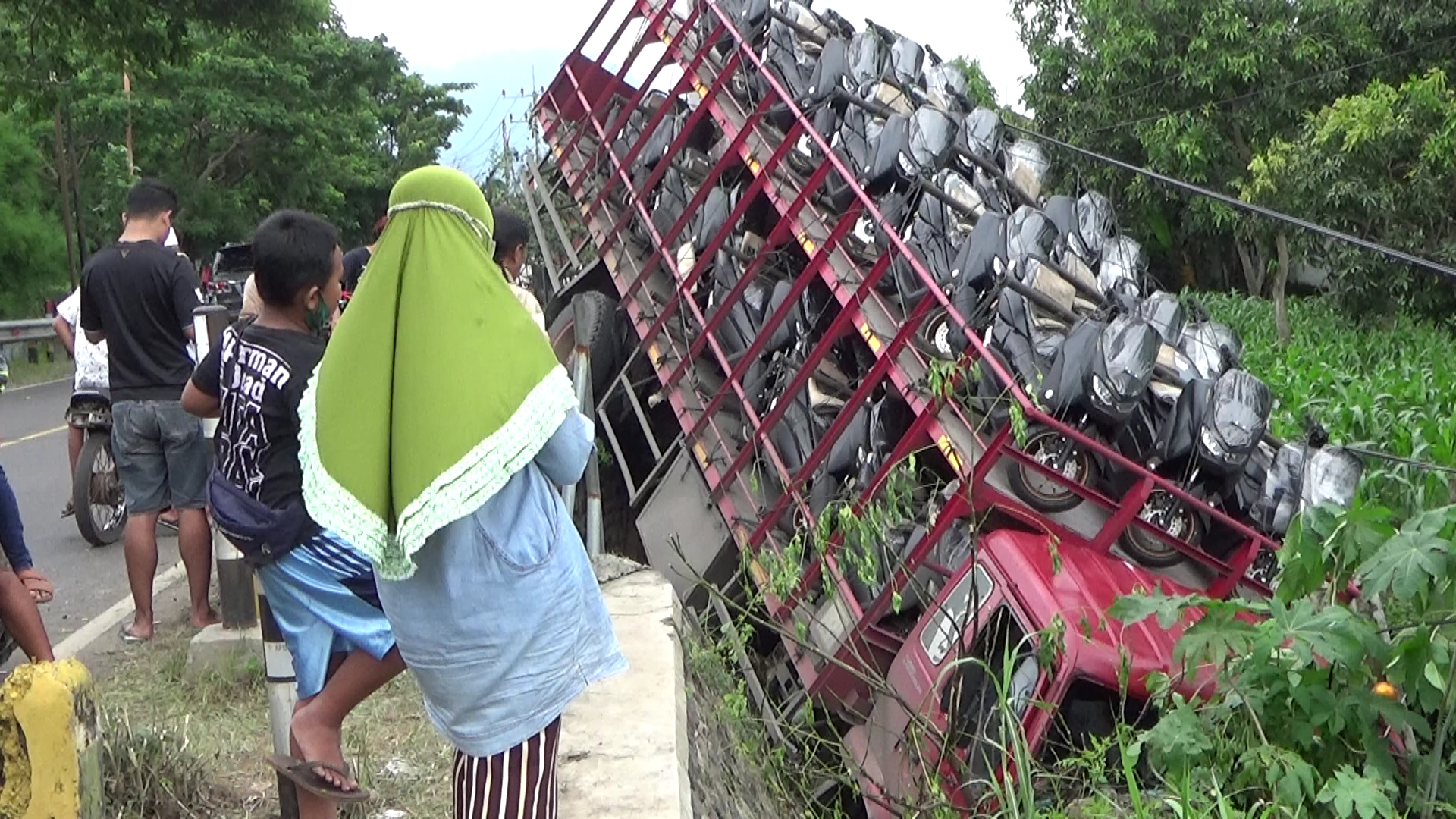 Warga melihat truk bermuatan sepeda motor baru yang di wilayah Wongsorejo (foto:istimewa)