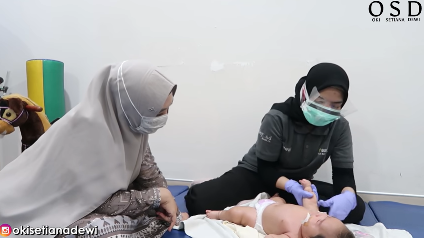 Oki Setiana Dewi memperhatikan cara terapi kepada sang anak untuk bisa dipraktikkan di rumah. (Foto: YouTube Oki Setiana Dewi)