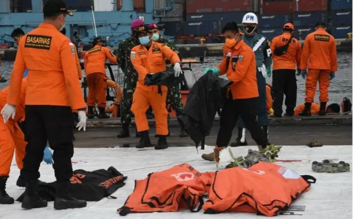 Personel Basarnas membawa kantong jenazah berisi objek temuan dari lokasi jatuhnya pesawat Sriwijaya Air PK-CLC nomor penerbangan SJ 182 rute Jakarta-Pontianak di Dermaga JICT II, Tanjung Priok, Jakarta Utara, Minggu 17 Januari 2021. (Foto: Antara/Indrianto Eko Suwarso)