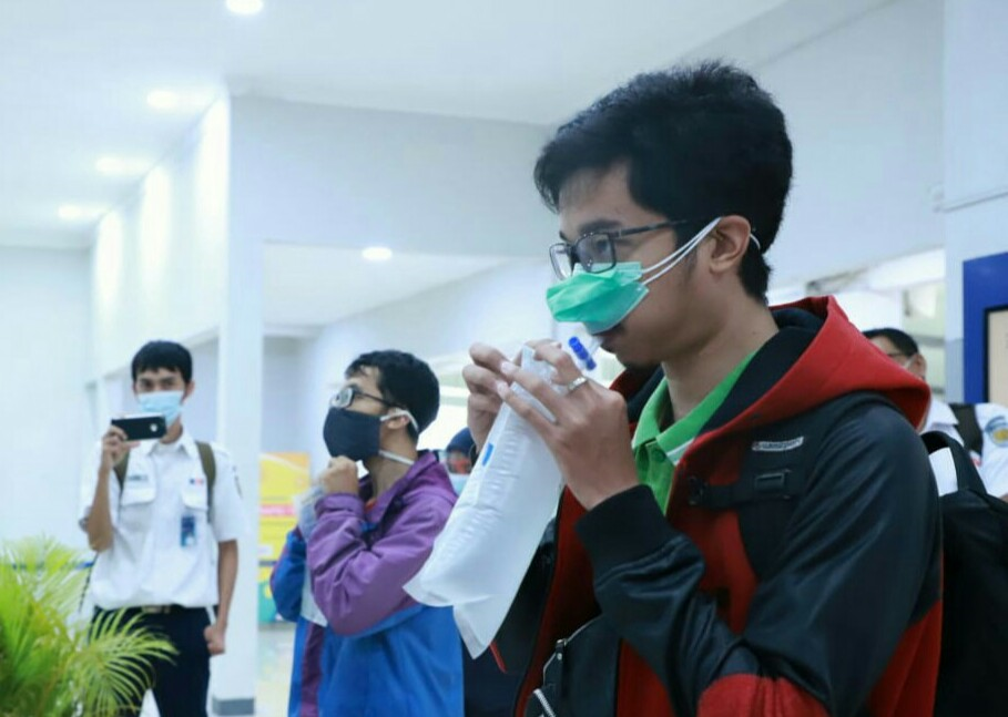 Seorang calon penumpang kereta api di Stasiun Senen sedang menjalani layanan GeNose dengan cara meniup kantong plastik, selanjutnya tiupan itu diproses oleh GeNose. ( Foto: Asmanu/Ngopibareng.id)