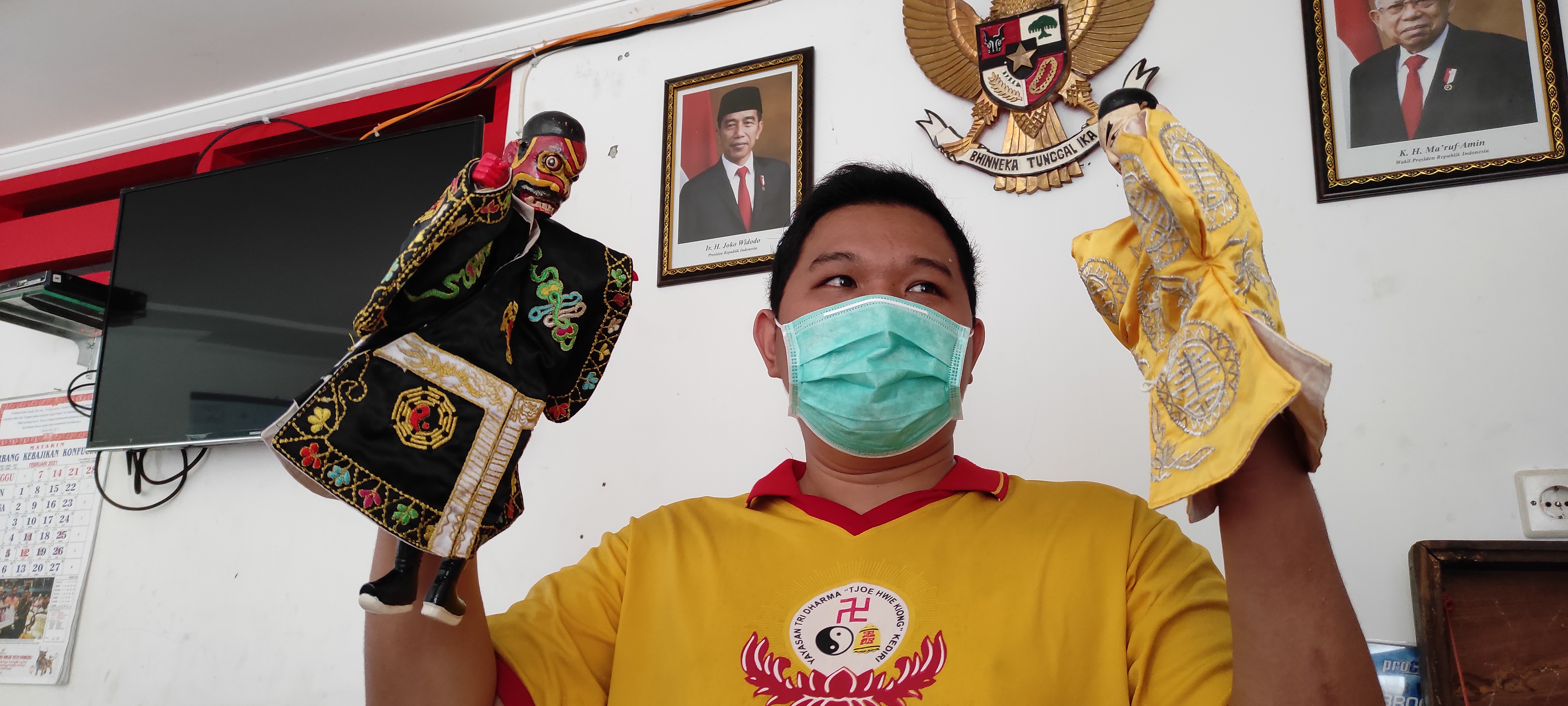 Halim Prayogo, salah satu pengurus Yayasan Tri Darma menunjukkan dua karakter wayang potehi yang biasa dimainkan. (Foto: Fendhy Plesmana/Ngopibareng.id)