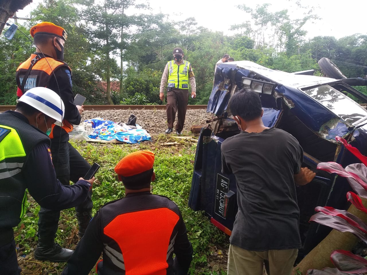 Polisi melakukan olah TKP di perlintasan kereta api dengan palang dan penjagaan 