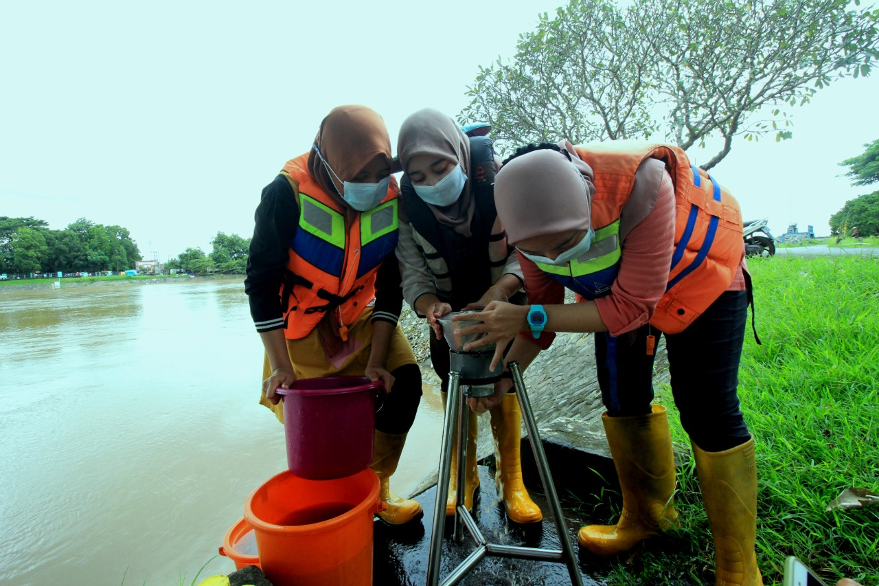 Tiga mahasiswa mengambil sample air untuk diuji cemaran mikroplastik. (Foto: Istimewa)