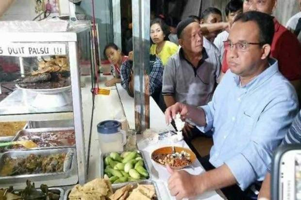 Gubernur DKI Jakarta Anies Baswedan sedang makan di warteg, kemudian menggigit diduga lengkuas. (Foto: Twitter @mazzinigsp)