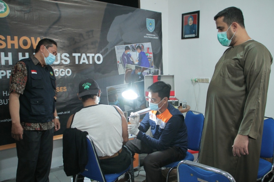 Seorang warga sedang menjalani penghapusan tato disaksikan Walikota Probolinggo, Hadi Zainal Abidin (kanan). (Foto: Ikhsan Mahmudi/Ngopibareng.id)