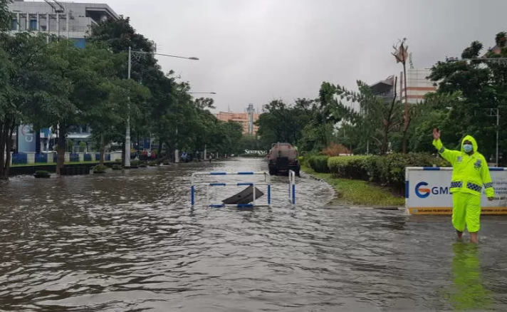 Petugas mengarahkan kendaraan yang akan melintas di kawasan Simpang Lima Semarang, Jawa Tengah yang tergenang air akibat hujan lebat, Selasa 23 Februari 2021. (Foto: Antara/I.C.Senjaya)