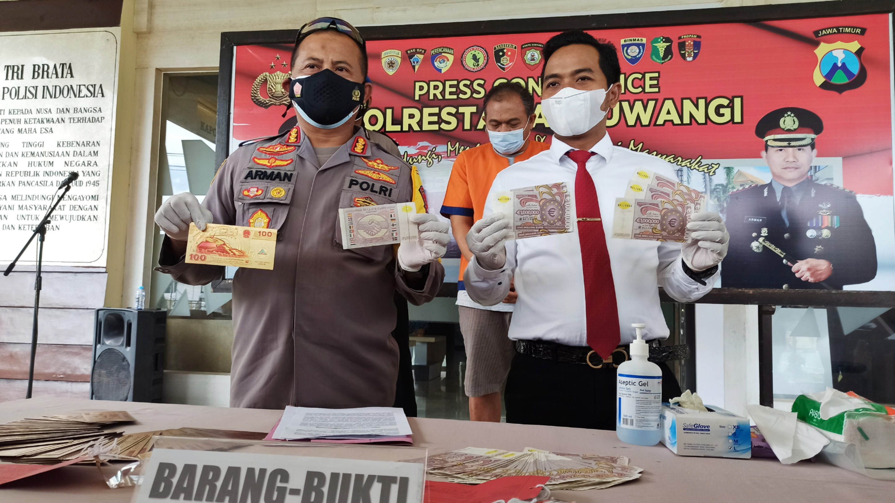 Kapolresta Banyuwangi Kombespol Arman Asmara Syarifuddin menunjukkan uang euro dan Yuan hasil pengembangan dari kasus sindikat Dolar palsu (foto: Muh Hujaini/Ngopibareng.id)