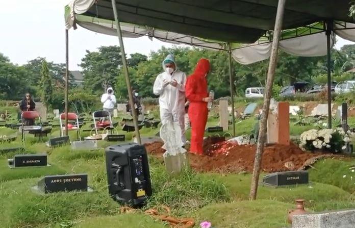 Teddy Syah ditemani anak lelakinya mengadzani jenazah Rina Gunawan, lalu berdoa hingga tabur bunga. (Foto: Istimewa)