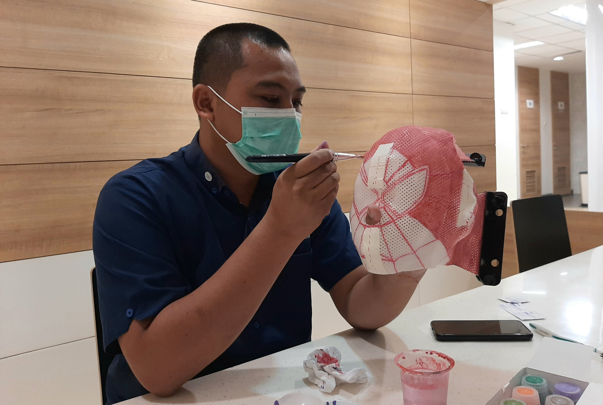 Deny Ary Sandy saat membuat Thermoplastic Mask karakter untuk anak-anak. (Foto: Pita Sari/Ngopibareng.id)