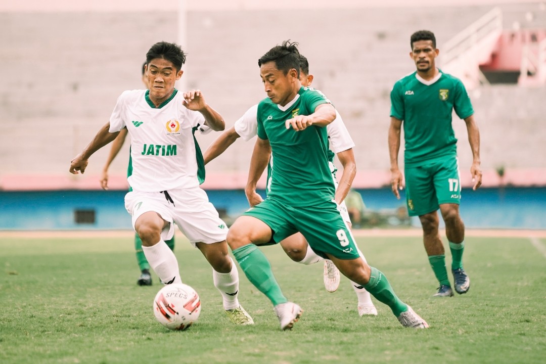 Samsul Arif mencoba melewati hadangan pemain tim PON Jatim. Samsul berhasil mencetak dua gol dari set piece. (Foto: Persebaya)