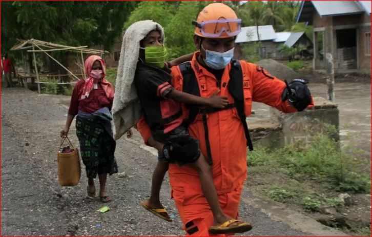  Foto dokumentasi seorang anggota Basarnas mengendong bocah ketika tim gabungan mengevakuasi warga yang masih bertahan dalam kawasan rawan bencana (KRB) III erupsi gunung api Ili Lewotolok di kecamatan Ile Ape Timur, NTT Kamis, 3 Desember, 2020. (Foto: Antara/Kornelis Kaha)