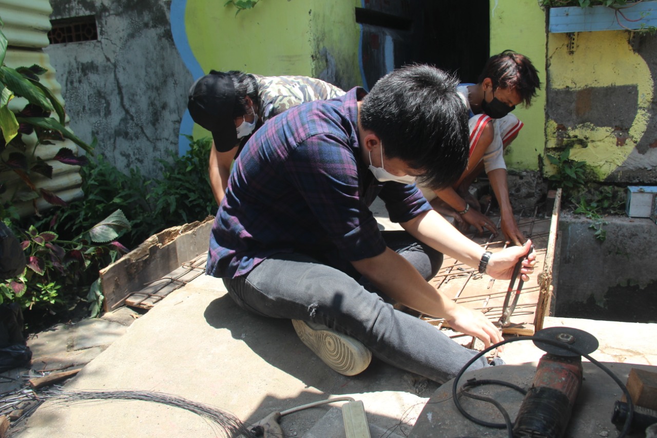 Mahasiswa UK Petra bergotong royong membuat batas jembatan untuk warga Bendul Merisi, Surabaya. (Foto: Dok. UK Petra)