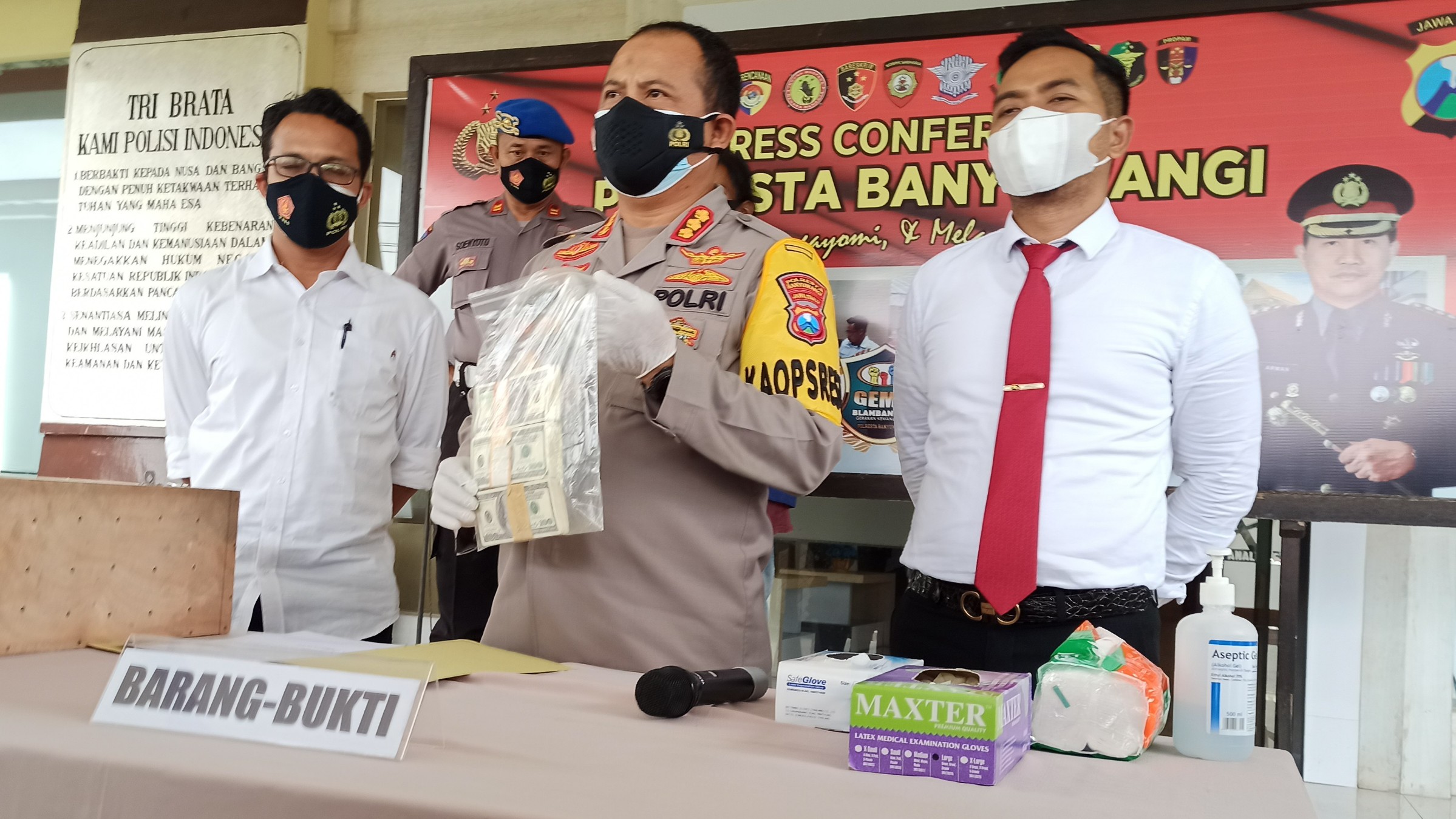 Kapolresta Banyuwangi Kombespol Arman Asmara Syarifuddin menunjukkan barang bukti dolar palsu  yang diamankan dari Mbah BE. (foto:Muh Hujaini/Ngopibareng.id)