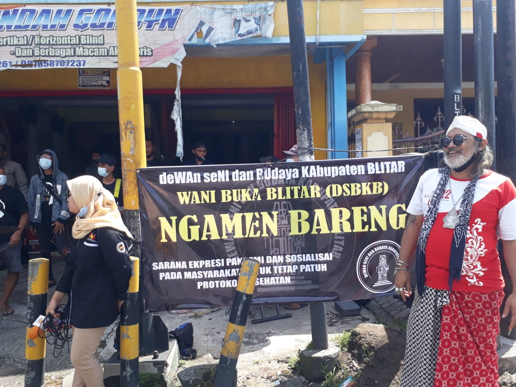 Dian Brew, Ketua Dewan Kesenian Kabupaten Blitar sekaligus koordinator lapangan Ngamen Bareng sebagai bentuk keprihatinan para seniman Blitar yang lama mengganggur akibat pandemi Covid-19. Ngamen Bareng digelar di perempatan Jalan Kanigoro, Kabupaten Blitar, Kamis 1 April 2021. (Foto: Choirul Anam/Ngopibareng.id)