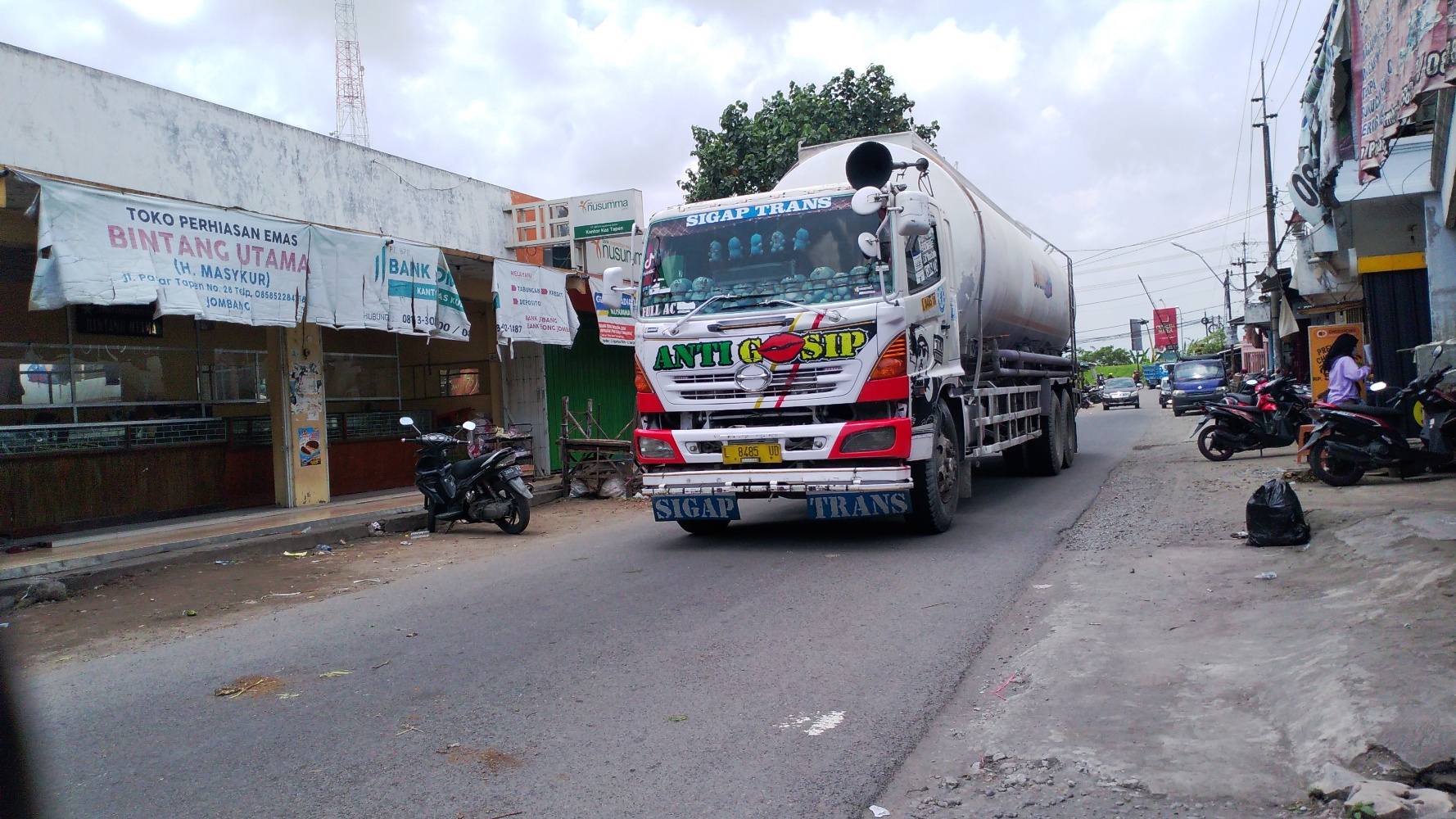 Kondisi lalu lintas di Pasar Tapen, Kecamatan Kudu, yang ramai dilintasi kendaraan lebih dari dua sumbu. Kondisi ini terjadi sejak adanya pengalihan arus kendaraan akibat proyek pembangunan jembatan baru Ploso. (Foto: Mardiansyah Triraharjo/Ngopibareng.id)