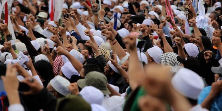 Umat muslim mengikuti aksi 212 di depan Kompleks Parlemen Senayan, Jakarta Pusat, Selasa (21/2). (Foto: Kompas)