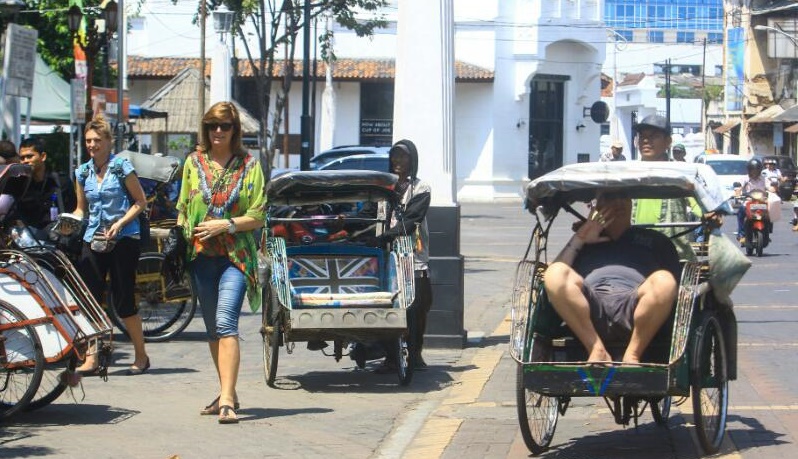 Tampak beberapa turis yang tegah asyik berkeliling Kota Semarang dengan menggunakan transportasi becak, Rabu (5/4).