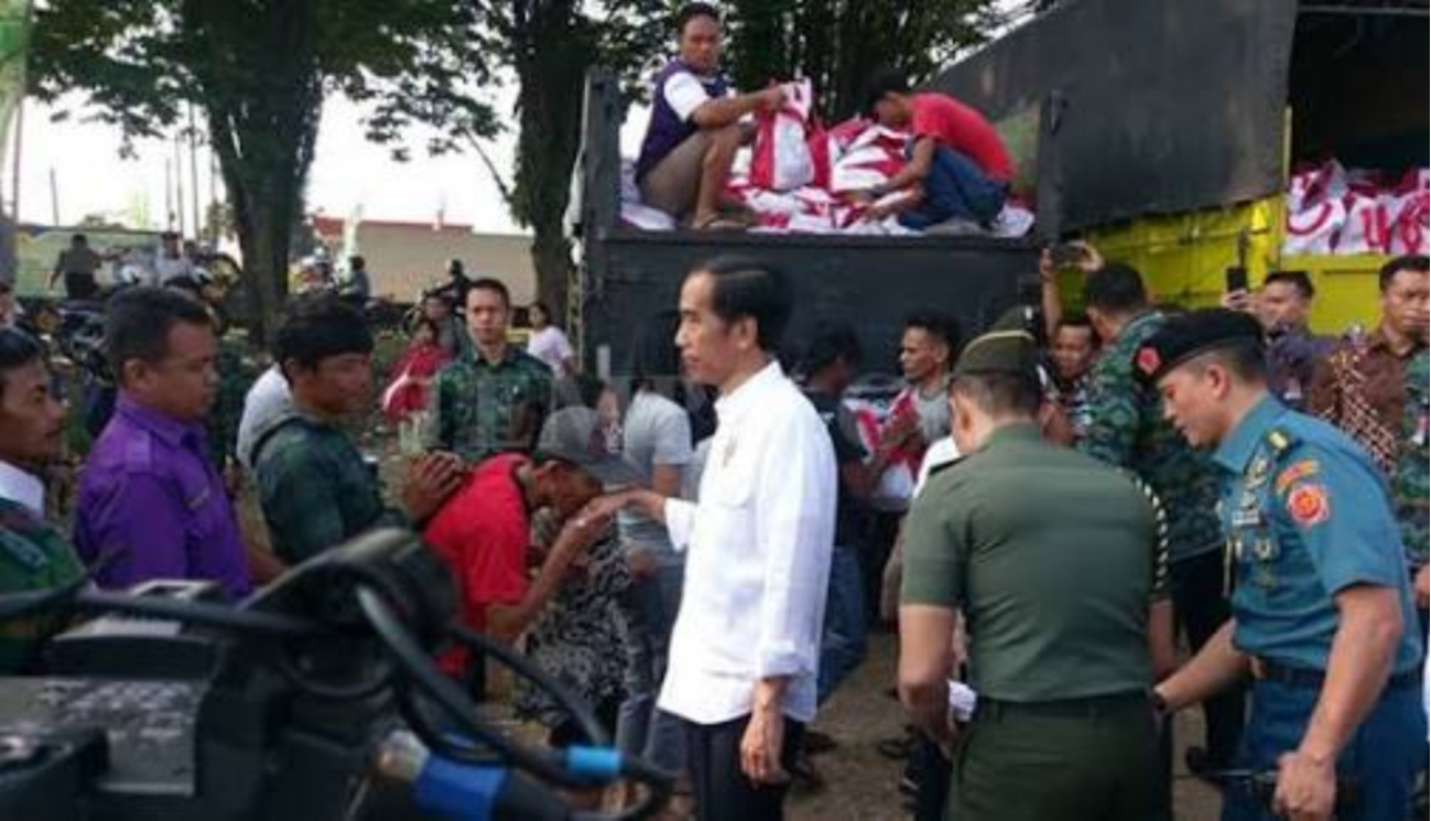 BAGI SEMBAKO: Presiden Jokowi menyalami warga yang antre sembako di Kampung Ciawi, Bogor. (Foto Biro Pers/Setpres)