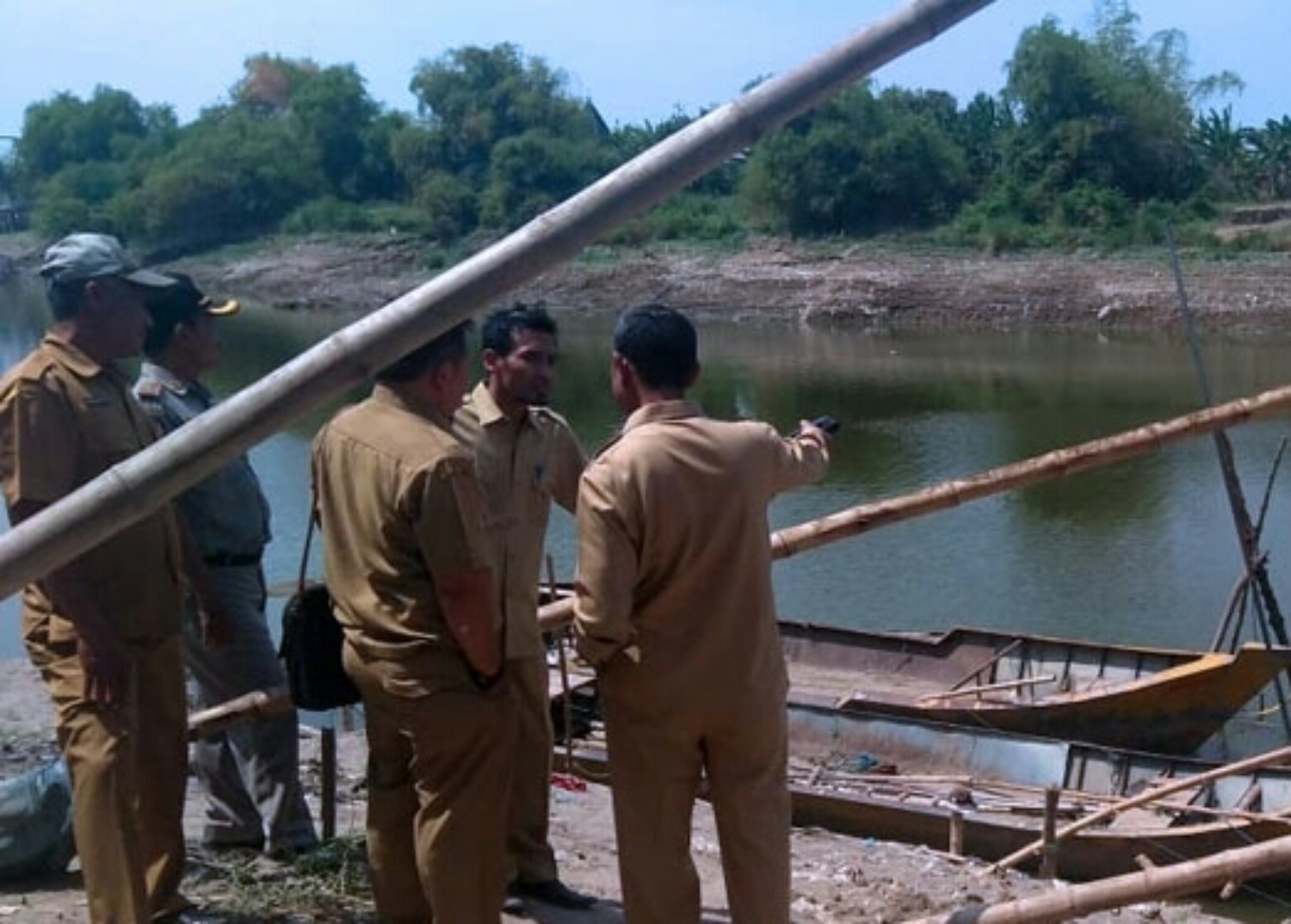 Petugas Disparbud Lamongan saat meninjau lokasi penemuan perahu di dasar Bengawan Solo. (Foto: Nasih/ngopibareng.id)